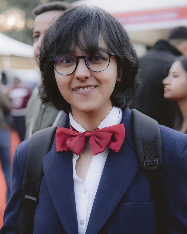 A portrait of a cosplayer dressed as Conan Edogawa from Detective Conan. The photo captures the character's signature smart and curious expression perfectly.
