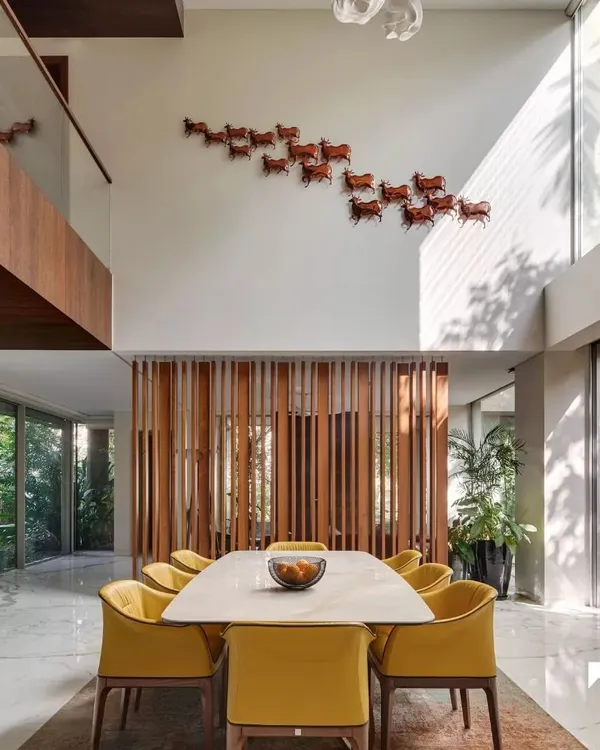 This is our Kanasu project, where a double-height dining area becomes the heart of the home. We used expansive windows to flood the space with natural light and connect it directly to the lush green outdoors, creating a feeling of immense volume and openness.