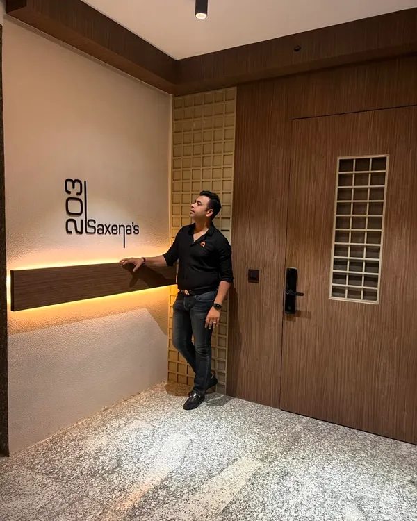 The main entrance transformation is complete. I designed this foyer with a custom backlit nameplate, wood-paneled walls, and a new door to create a warm and welcoming first impression.