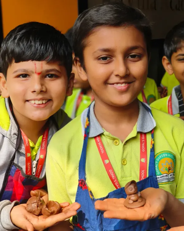Two young students from Gopal's Garden School proudly show off the miniature clay articles they made. Their smiles say it all; our workshops are a joyful and creative experience for kids.