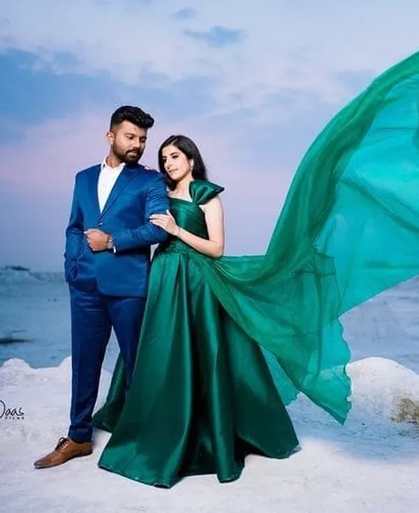 A dramatic emerald green gown with a long, flowing trail, perfect for a pre-wedding photoshoot. I designed this to create a striking contrast against any backdrop.