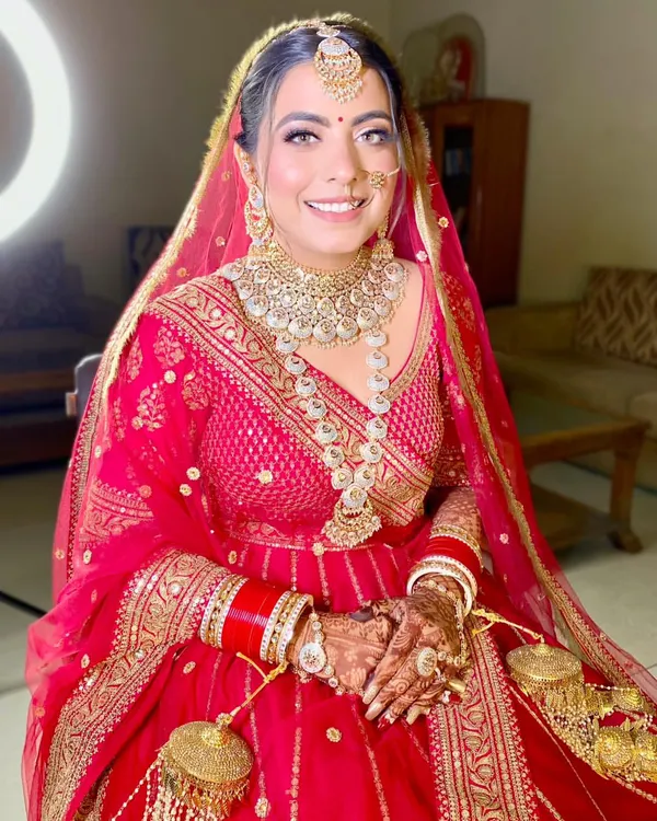 My gorgeous bride Neha is a vision in red. This look features a classic red lip, defined eyes, and radiant skin, perfectly complementing her traditional bridal attire.