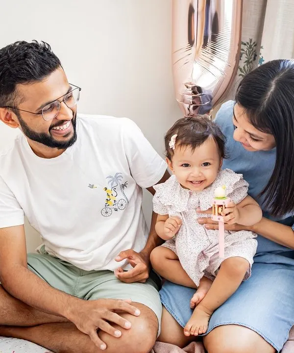 A happy family moment on the bed, celebrating their daughter's first birthday. These candid, at-home sessions are all about capturing genuine smiles and interactions.