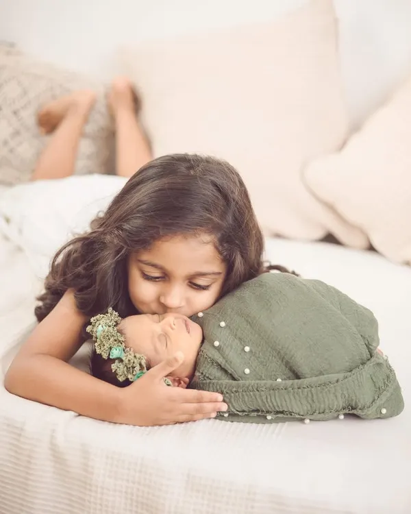 A tender kiss for a new baby sister. These are the moments we live for, capturing the beginning of a lifelong friendship in our newborn and sibling sessions.