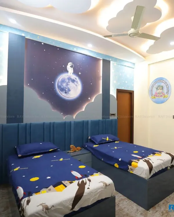 A dreamy kids' room with a space-themed wallpaper, featuring an astronaut on the moon. The room has two single beds with matching blue bedding, perfect for siblings.