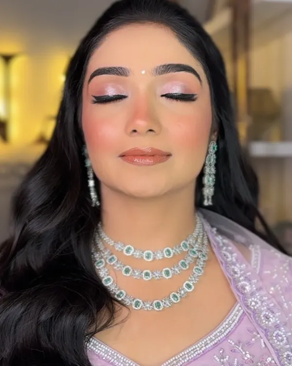 A close-up of this bride-to-be's soft glam look. The focus is on the shimmery pink eyeshadow and perfectly blended, glowing skin, ideal for an engagement ceremony.