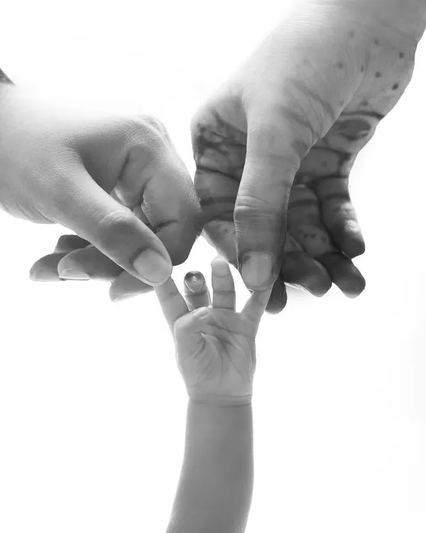 A tiny hand reaching for its parents. This black and white detail shot is a powerful and symbolic representation of family and connection.