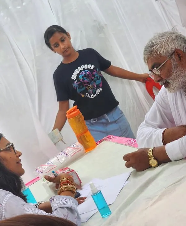 Continuing my father's vision, we organized a medical camp offering free vital checks, doctor consultations, and diet advice. Here I am providing a personalized diet consultation to one of the attendees.