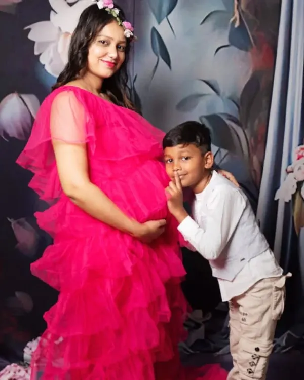 A sweet maternity photo with the older sibling sharing a secret with the baby bump. It's a beautiful way to include the whole family in the excitement.