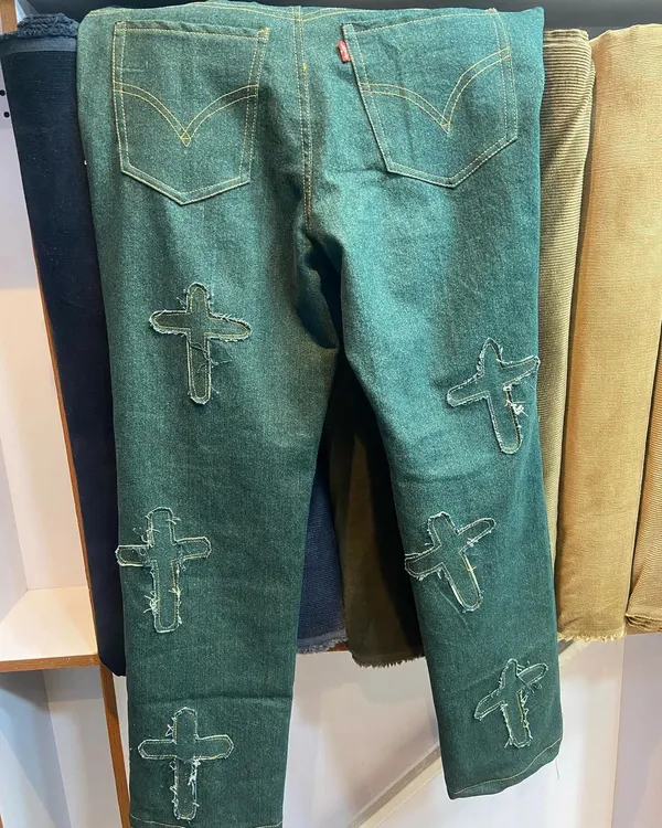 An example of bold customization. These green denim jeans feature custom-made, frayed-edge cross patches for a unique, standout look.