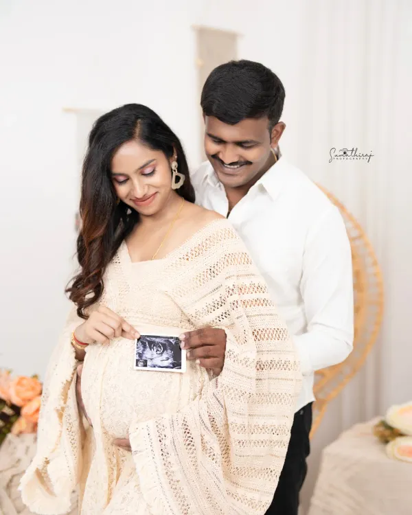 A beautiful boho-chic portrait of a couple holding their baby's first ultrasound picture. The natural textures and soft lighting create a warm and intimate atmosphere.