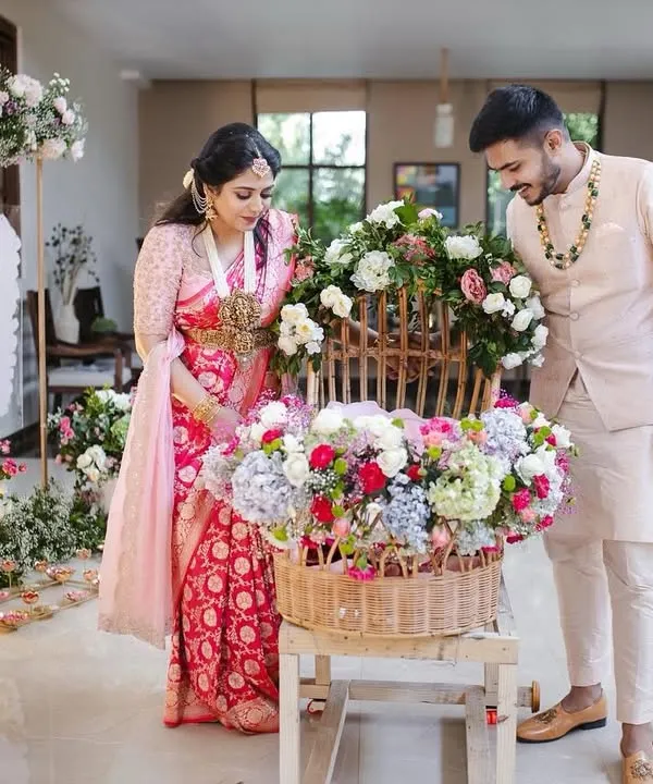 A beautiful moment from Inara's naming ceremony. The new parents admire a basket of flowers, a symbol of the new life and beauty they are celebrating. The decor is soft, pastel, and full of love.