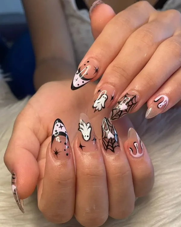 A full view of my custom Halloween nail art. This set features hand-painted ghosts, spiderwebs, moons, and stars on long, clear stiletto extensions for the perfect spooky season look.