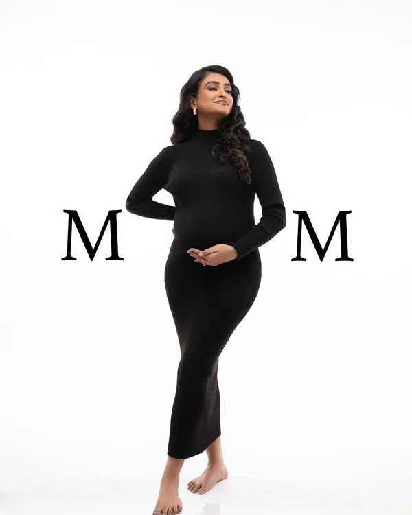 A powerful and stylish full-length portrait in a classic black turtleneck dress. The simple white background and bold "MOM" text make a modern statement.