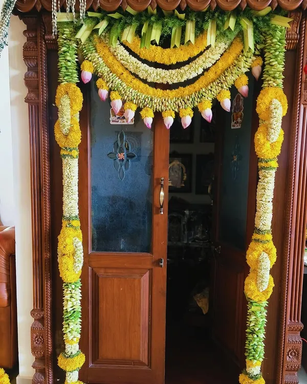 A traditional door decoration for a housewarming ceremony. I used garlands of yellow chrysanthemums and jasmine, with hanging lotus buds for an elegant and auspicious touch.