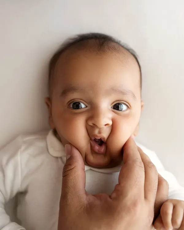 Those squishy newborn cheeks are my favorite! A playful pinch from dad brings out the cutest expression. These are the fun, memorable shots we capture during a newborn session.