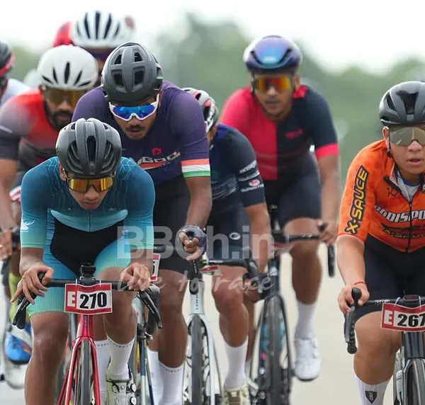 The elite peloton is a blur of color and speed. Here, riders are tightly packed, drafting off one another in a display of high-stakes road racing strategy.