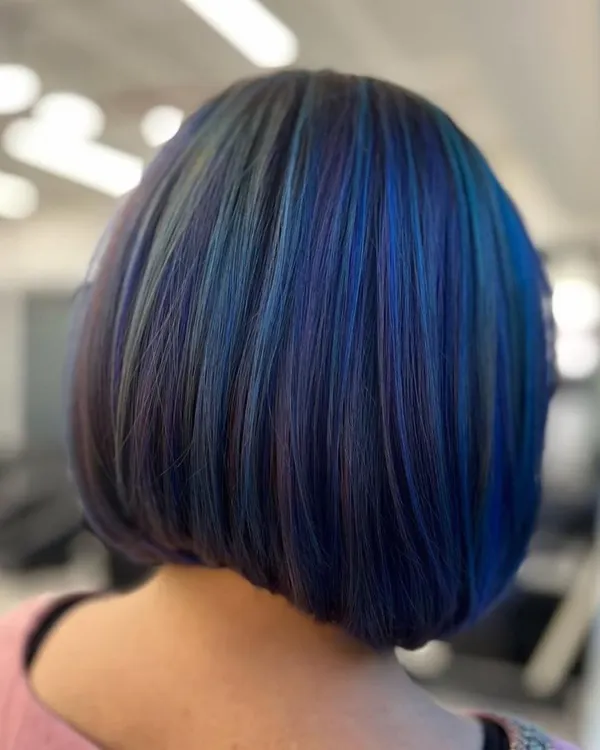 A mesmerizing fusion of teal and purple on a sharp bob. This shows how vivid colors can be used to create a sophisticated, high-fashion look.