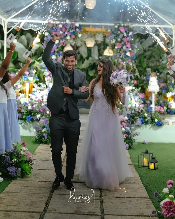 A couple's joyous entrance into their enchanted garden reception. This is the moment a fairy tale comes to life, with a pathway of flowers and cold pyro creating a magical, unforgettable memory.