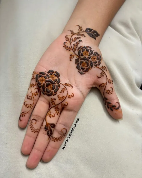 A very elegant and contemporary design featuring a delicate floral vine that gracefully flows across the palm and fingers.