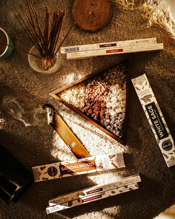 A cozy, sunlit flatlay of aromatic incense sticks and resins on a textured jute mat. This lifestyle shot creates a warm and calming atmosphere, perfect for wellness and home fragrance brands.