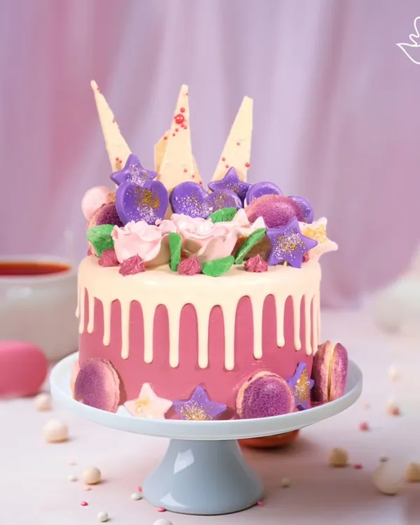 A dreamy and romantic cake for Vanya and Paarth's anniversary in Kalkaji. This pink drip cake is adorned with macarons, edible glitter, and white chocolate shards for a touch of modern luxury.