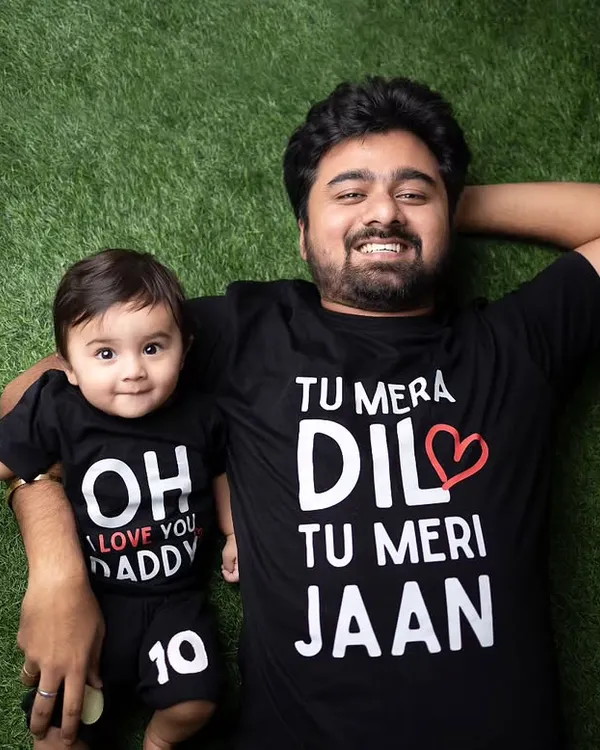 A fun and creative shot of a father and son in matching t-shirts. This overhead photo on a green turf background is playful and shows a lot of personality.