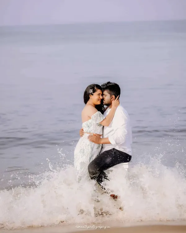 A couple shares an intimate moment amidst the ocean waves at Honnavar beach. This shot captures the playful and romantic energy of a destination pre-wedding shoot.