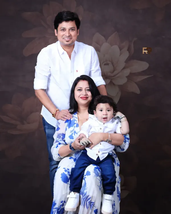 A classic family portrait with mom, dad, and their little one. Coordinated outfits and a simple, elegant backdrop ensure that the focus remains on the family's connection and happiness.
