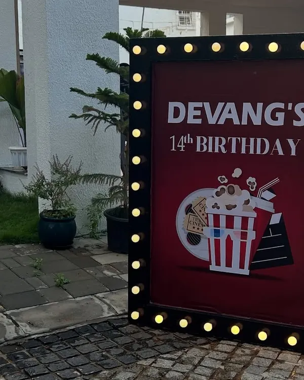 A movie-themed birthday party entrance sign with marquee lights, perfect for a unique celebration at home.