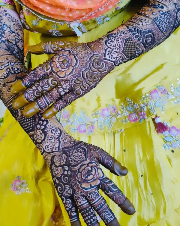 A beautiful bridal design with a rich, dark stain, posed against a vibrant yellow outfit.
