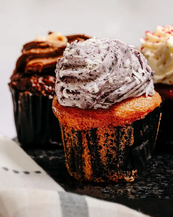 A mouth-watering close-up of a cupcake, focusing on the creamy frosting and rich texture. This type of shot is designed to trigger appetite and drive sales.