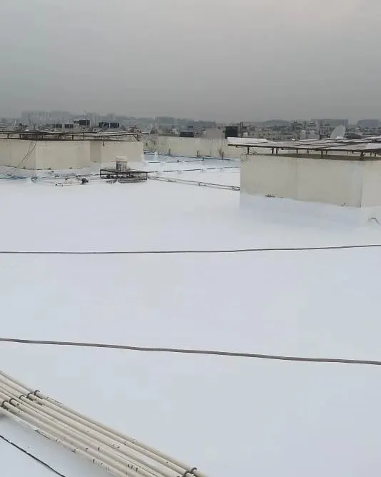 A finished terrace with a bright white, heat-reflective waterproof coating. This seamless application not only stops leaks but can also help in reducing heat absorption, keeping the rooms below cooler.