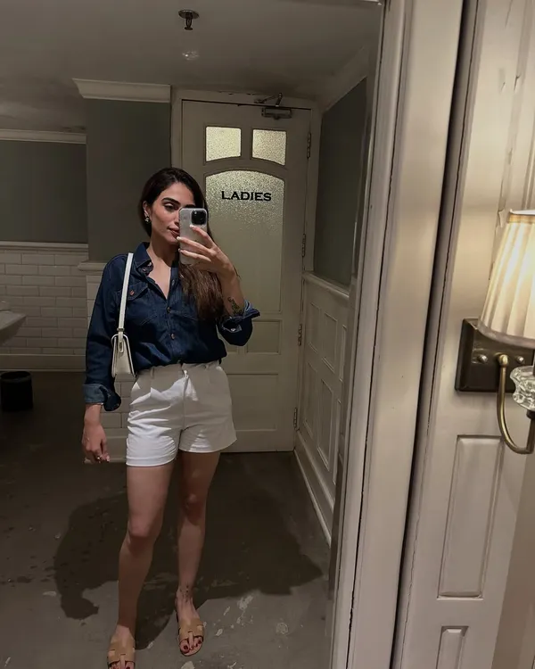 A classic summer look featuring a dark denim shirt and white shorts. This is a simple, no-fuss outfit perfect for a casual day out.