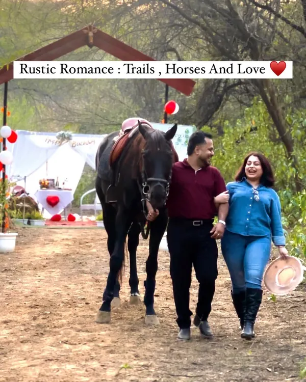 A happy couple walks with one of our majestic horses towards their private romantic setup. This is the perfect start to our "Trail of Love" experience, blending adventure with an intimate celebration.