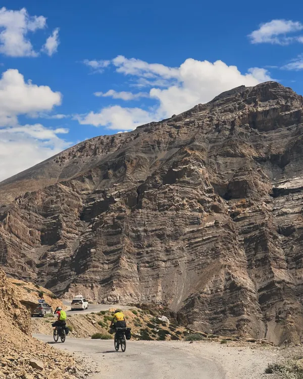 This is what it's all about. Two riders on the iconic Manali to Leh cycling expedition, dwarfed by the immense beauty of the Ladakh landscape. We believe in raw, real adventures, and this is one of our biggest.