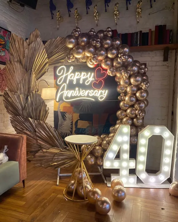 This 40th-anniversary setup is a great example of a grand party decoration. I used a custom neon sign, large light-up marquee numbers, and a full arch of metallic gold balloons to create a luxurious and celebratory photo corner.