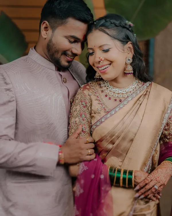 A candid moment of shared laughter between Karishma and Bhaskar, showcasing the beautiful embroidery on the bride's blouse and her traditional green bangles.