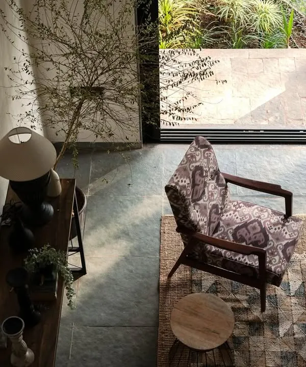 A top-down view of the living area in Maison Rouge, a family vacation home in the Konkan belt. The design balances contemporary details with traditional materials, creating an oasis that connects the family to their ancestral roots.