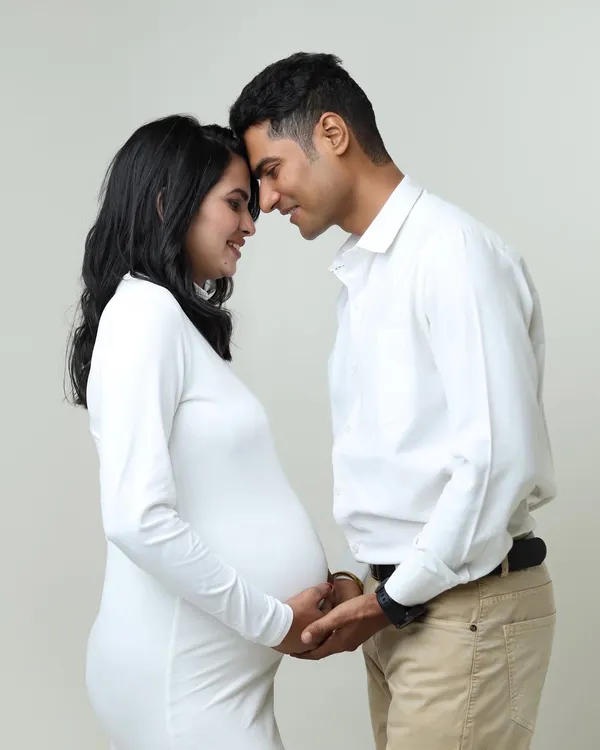 A classic and intimate pose, with the couple forehead-to-forehead. This captures the deep connection and shared anticipation in a simple, beautiful way.