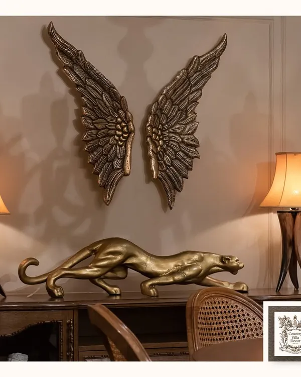 This powerful decorative set features a stalking golden panther and dramatic angel wings in a burnished gold finish. Placed on a console, these metal art pieces create a bold and luxurious statement.