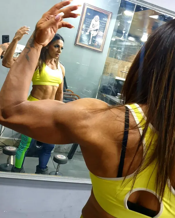 Checking my bicep definition in the mirror. My nutrition plans are tailored to help you build lean muscle mass while keeping body fat low, creating this kind of sharp, defined look.