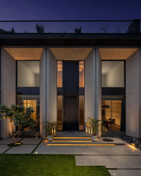 The exterior of the Mr. Light showroom at night, where architectural lighting emphasizes the building's strong vertical forms and creates an inviting, high-end presence.