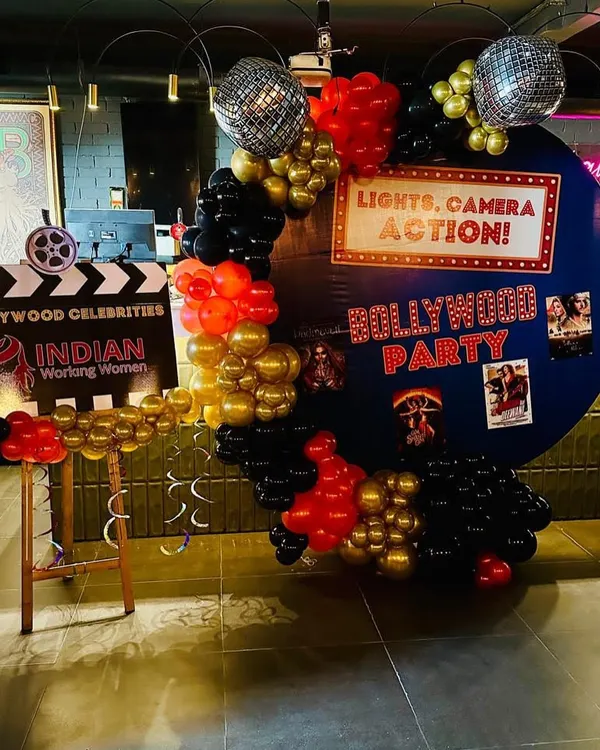 Lights, Camera, Action! A fun Bollywood-themed party setup, complete with a film clapboard and a backdrop of movie posters. Themed parties are a great way to add a layer of fun and get guests to dress up.