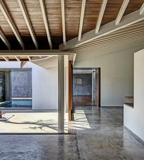 A central courtyard serves as the organizing principle in this design, creating a serene, open-air heart for the building. The polished concrete floors and natural wood ceiling frame the view, blurring the line between interior and exterior space.