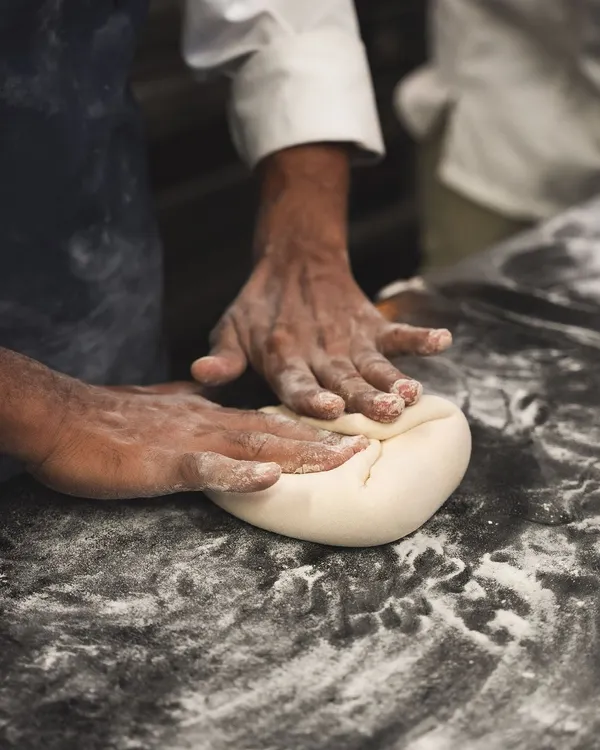 It all starts with the dough. Here, our baker is kneading sourdough by hand, a fundamental step to develop the gluten and structure for a perfect loaf.