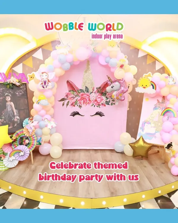 A magical unicorn-themed birthday setup. This beautiful backdrop with a floral unicorn, pastel balloons, and a golden arch creates a truly enchanting party atmosphere.