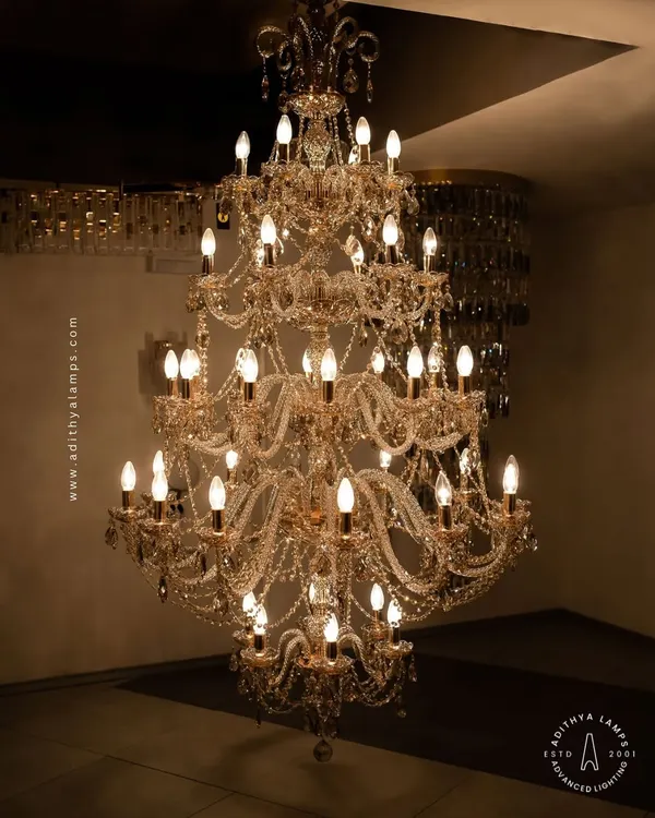 The epitome of luxury, this grand multi-tiered crystal chandelier is designed for double-height spaces. Its cascading crystal beads and classic candelabra bulbs create a dazzling display of light and opulence, perfect for grand entryways and formal living areas.