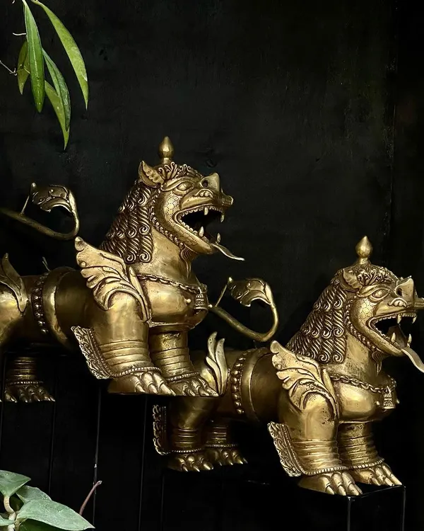 A pair of Tibetan temple lions, handcrafted from brass. These guardians are usually placed at an entrance to keep evil at bay, and their fierce expression and detailed form make them a powerful statement piece.