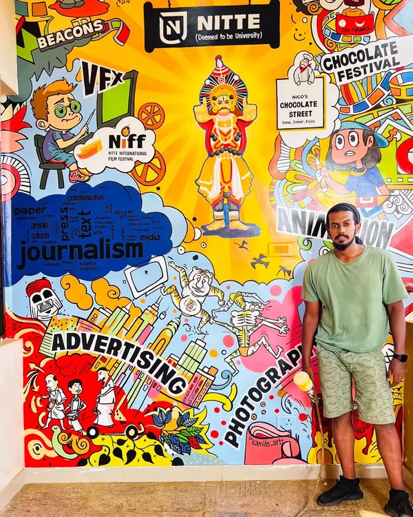 Here I am with the completed mural for the Nitte Institute of Communication. The artwork is a colorful doodle collage representing all the courses they offer, including journalism, VFX, animation, and photography, with a touch of local culture.